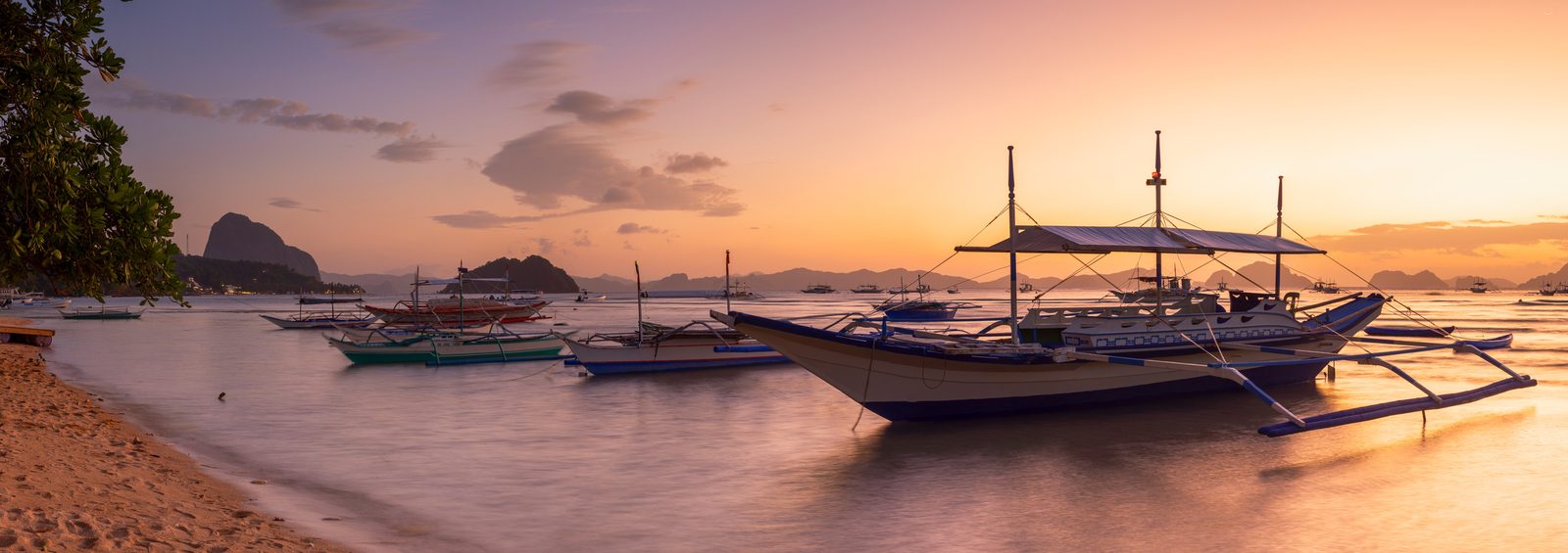 Bangkas at rest off Corong-Corong at sunset, the bay going orange.