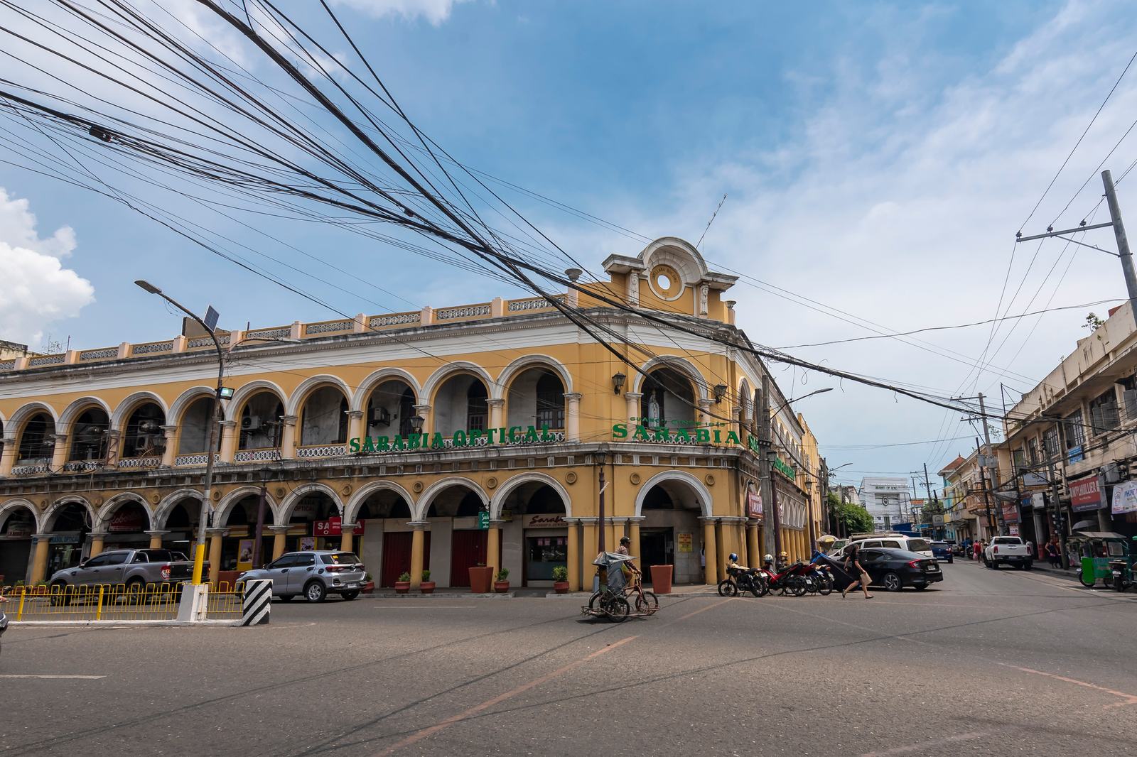 A restored arcaded heritage building on Iloilo&rsquo;s old streets, painted cream and yellow.