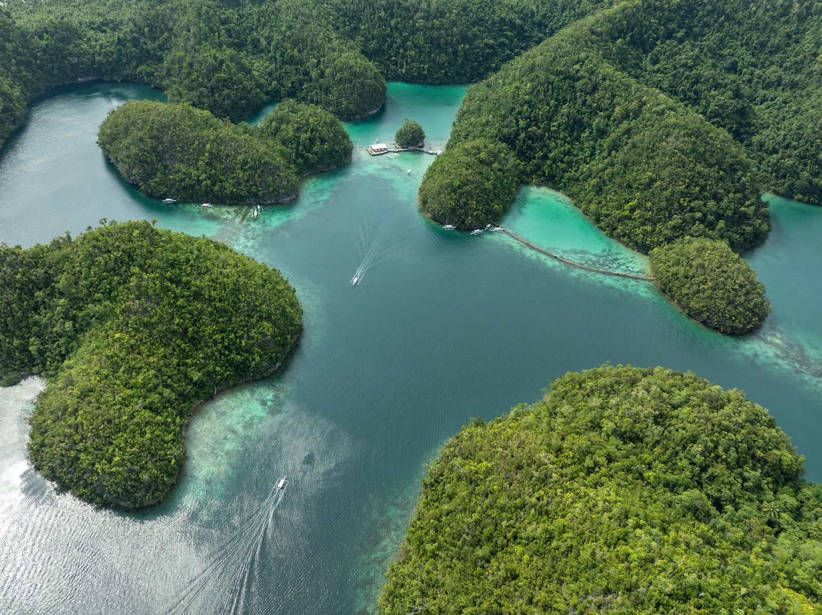 Green islets and turquoise channels of Siargao from the air.